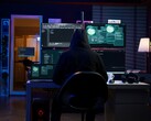 Ein Forscher mit Kapuze arbeitet in einem abgedunkelten Raum vor mehreren Bildschirmen – eine typische Darstellung eines Hackers